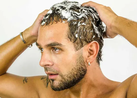 man shampooing hair