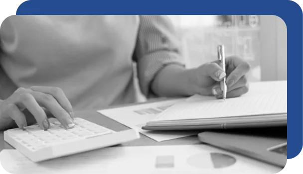 A worker uses both pen and paper and a robot (in the form of a calculator) to perform a routine task.