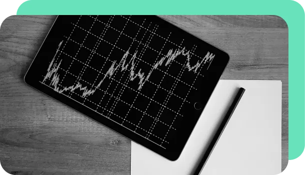 A tablet shows a chart with lines going up and to the right.