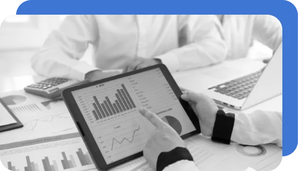 A team of people reviews charts on a tablet to perform financial risk management.