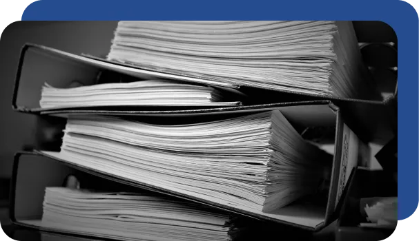 A huge stack of documents that would take many hours to manually create and organize without document automation.