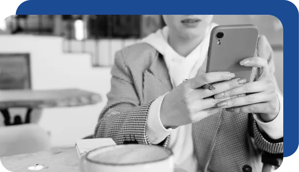 A person uses their phone in a cafe and connects to public Wi-Fi, putting them at risk for fraud.