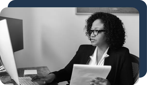 A women at a computer relies on artificial intelligence for fraud detection.