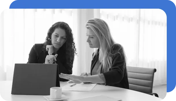 Two underwriters review application documents as part of the underwriting process.