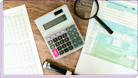 Credit charts, a calculator, a highlighter, and a tax document on a wooden table.