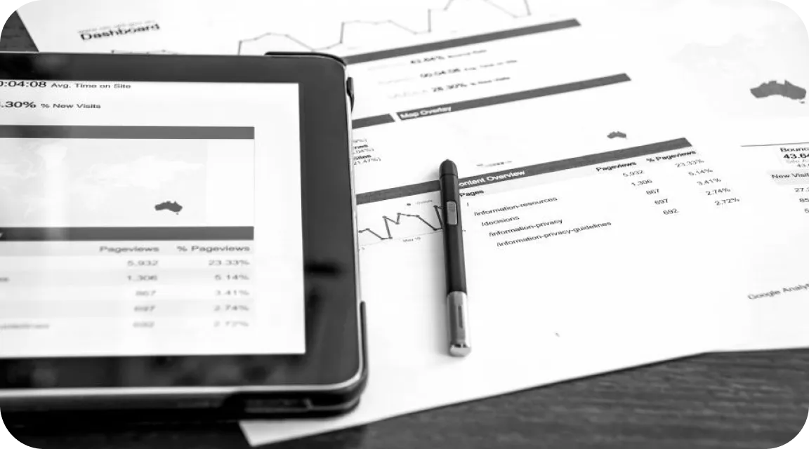 Tablet and printed financial documents on a desk, representing manual bank statement analysis and traditional financial review processes.