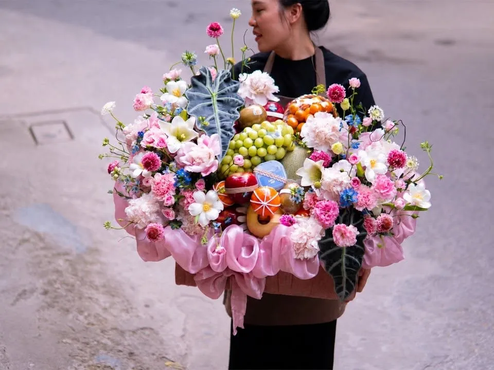 Cô gái xách giỏ hoa quả nho xanh, cam và hoa hồng trên đường phố — King Fruit huyện Đầm Hà, Quảng Ninh