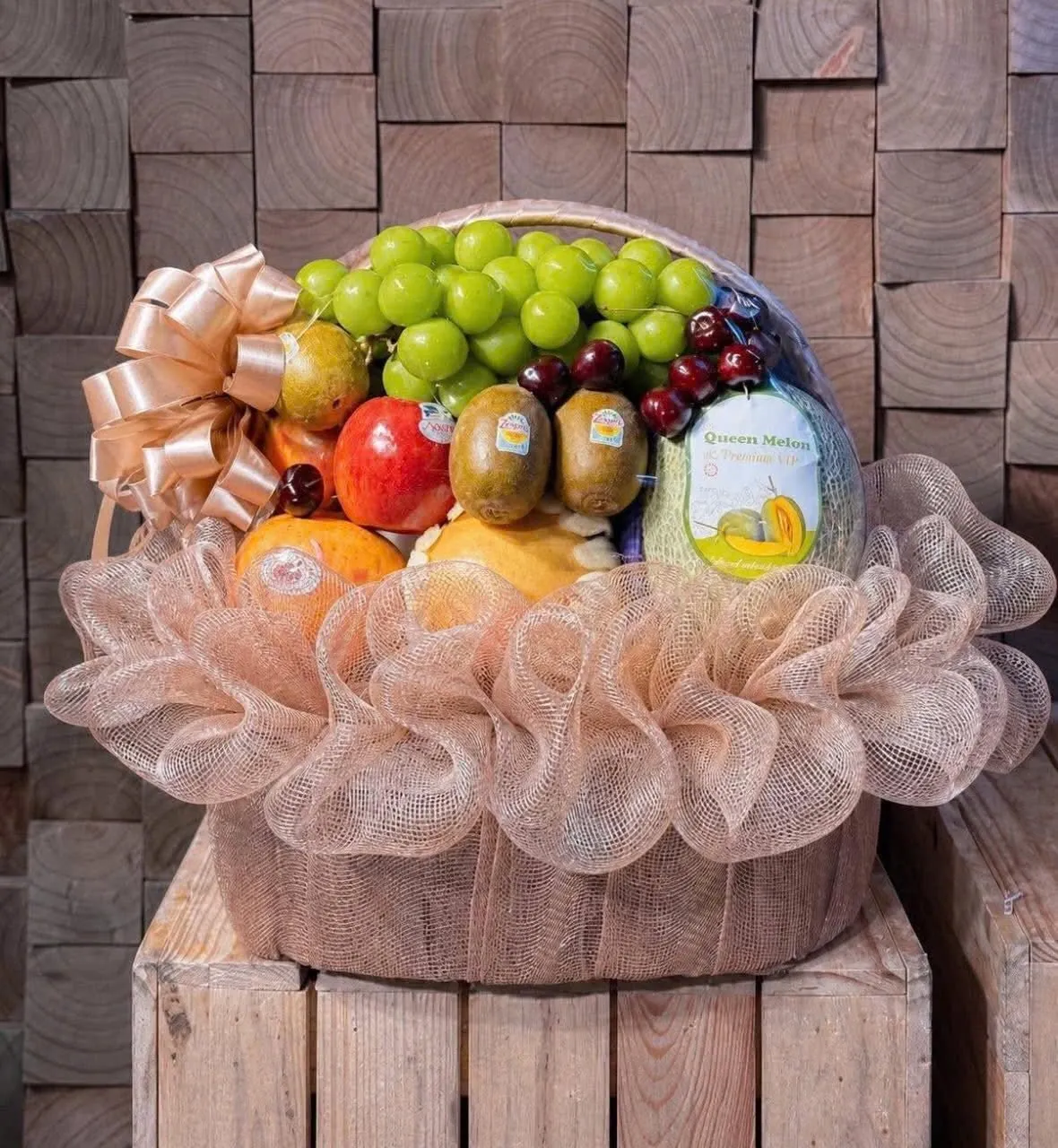 Cận cảnh giỏ hoa quả nho xanh, táo, kiwi, anh đào và dưa lưới trên nền gỗ — King Fruit Quảng Ngãi