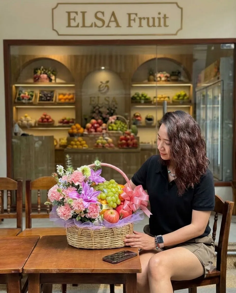 Khách ngồi bên giỏ mây nho xanh, táo và hoa hồng, lan tím tại ELSA Fruit — ELSA Fruit huyện Đắk Tô, Kon Tum