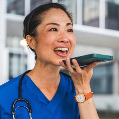 A female healthcare worker speaking into her smartphone