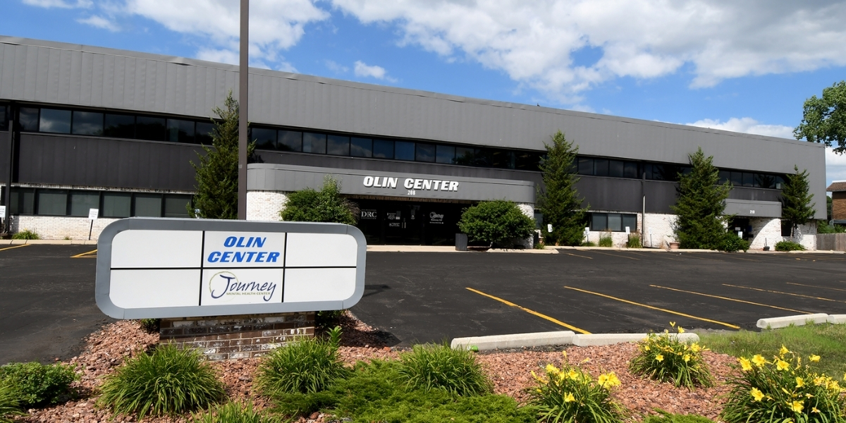 Grey business park building labeled Olin Center with sign out front