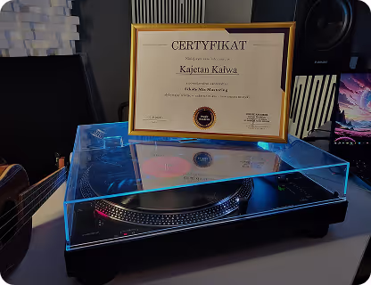 Certyfikat ukończenia kursu miksowania wyeksponowany na gramofonie studio.