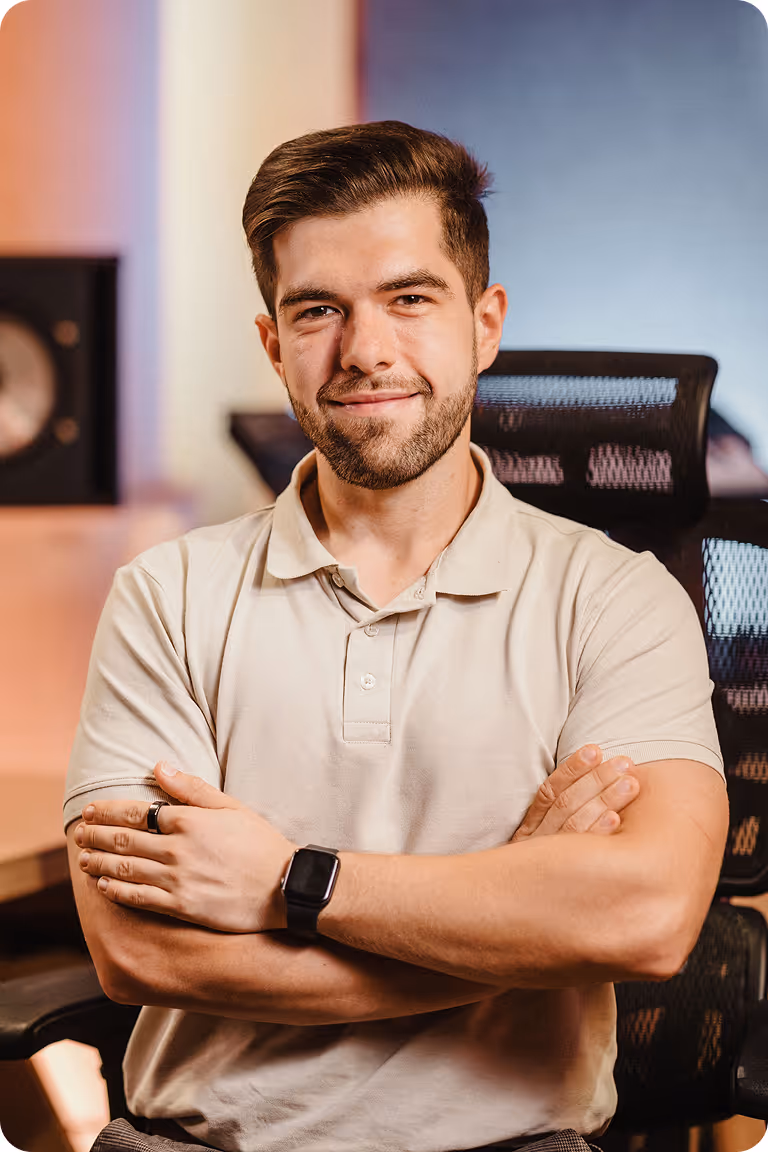 Tomasz Moskalski producent muzyczny z założonymi rękami w nowoczesnym studiu nagraniowym – profesjonalna produkcja muzyczna