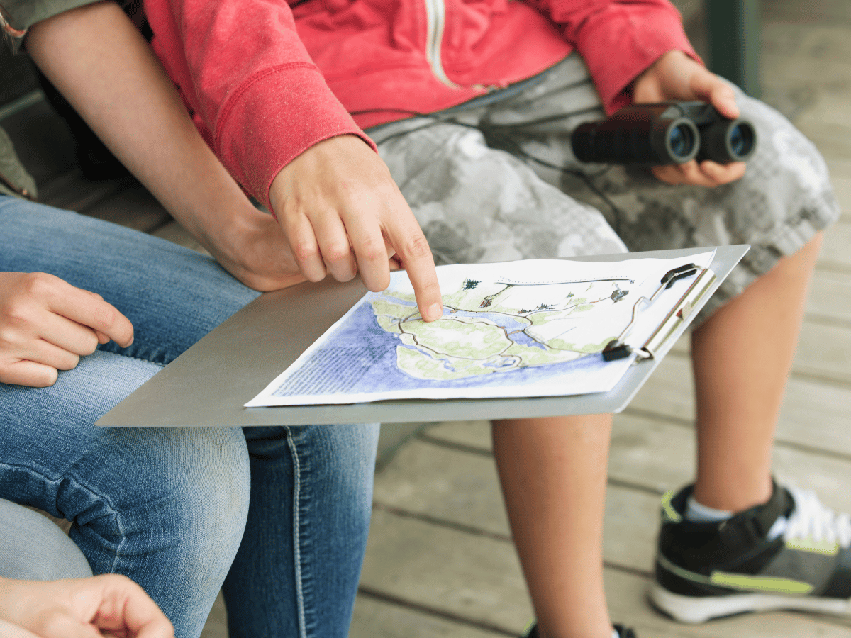 ADHD teen pointing at a hand-drawn map, representing an alternative assignment supporting ADHD school kids.