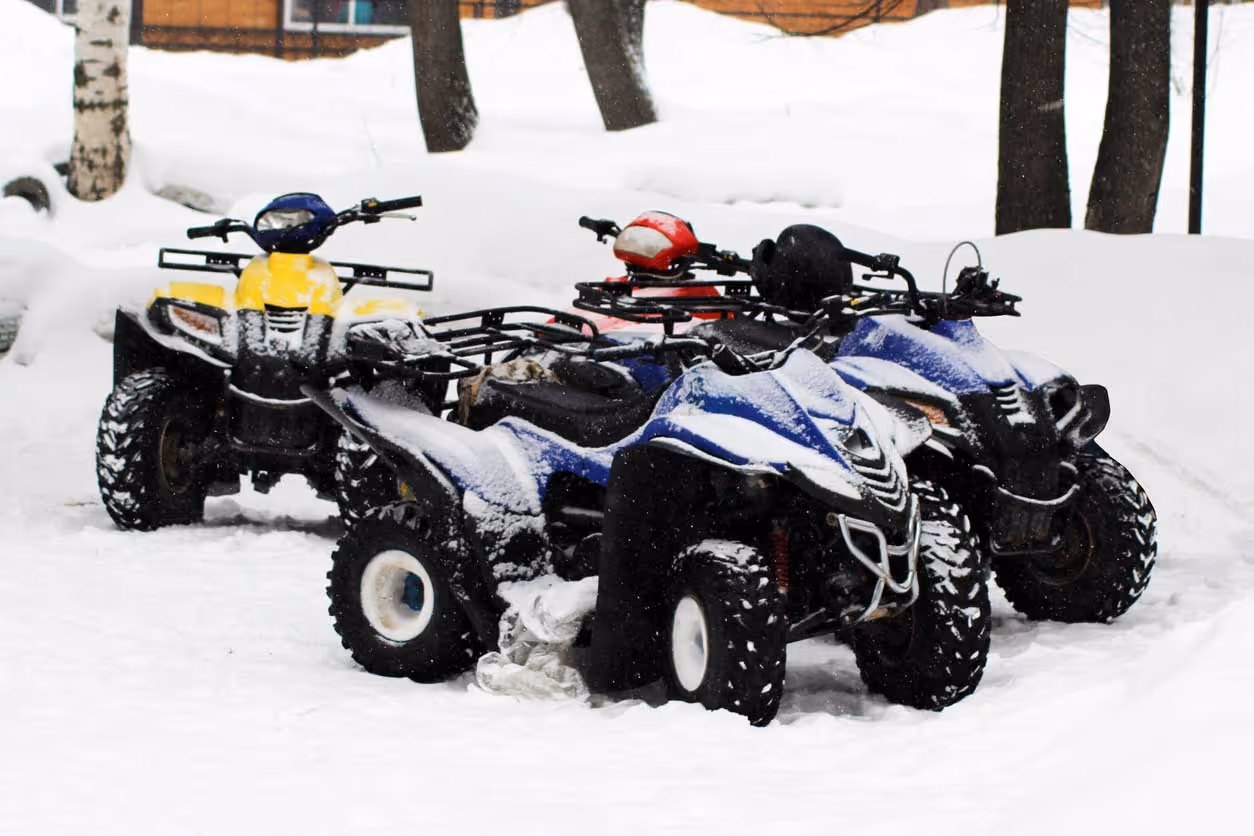 atvs lined up in the snow