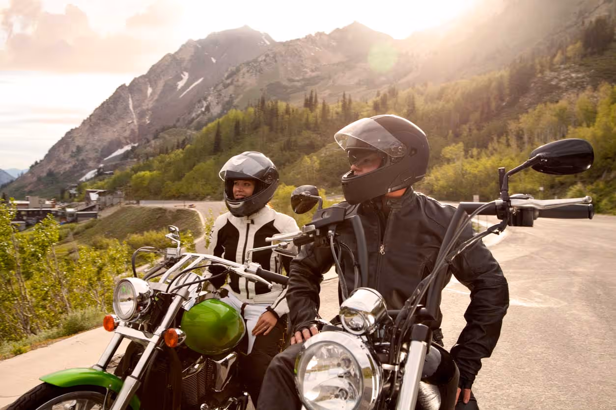 two motorcycle riders stopped on side of road