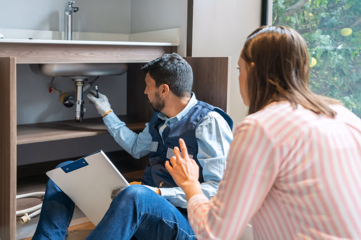 Plumber explaining to a client the problem with her kitchen sink