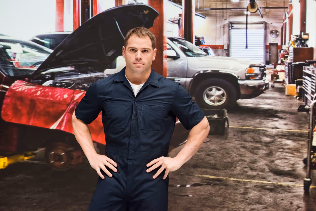 NH Garage Keepers Insurance concept - Caucasian young male manual worker repairing at the auto repair shop wearing coveralls