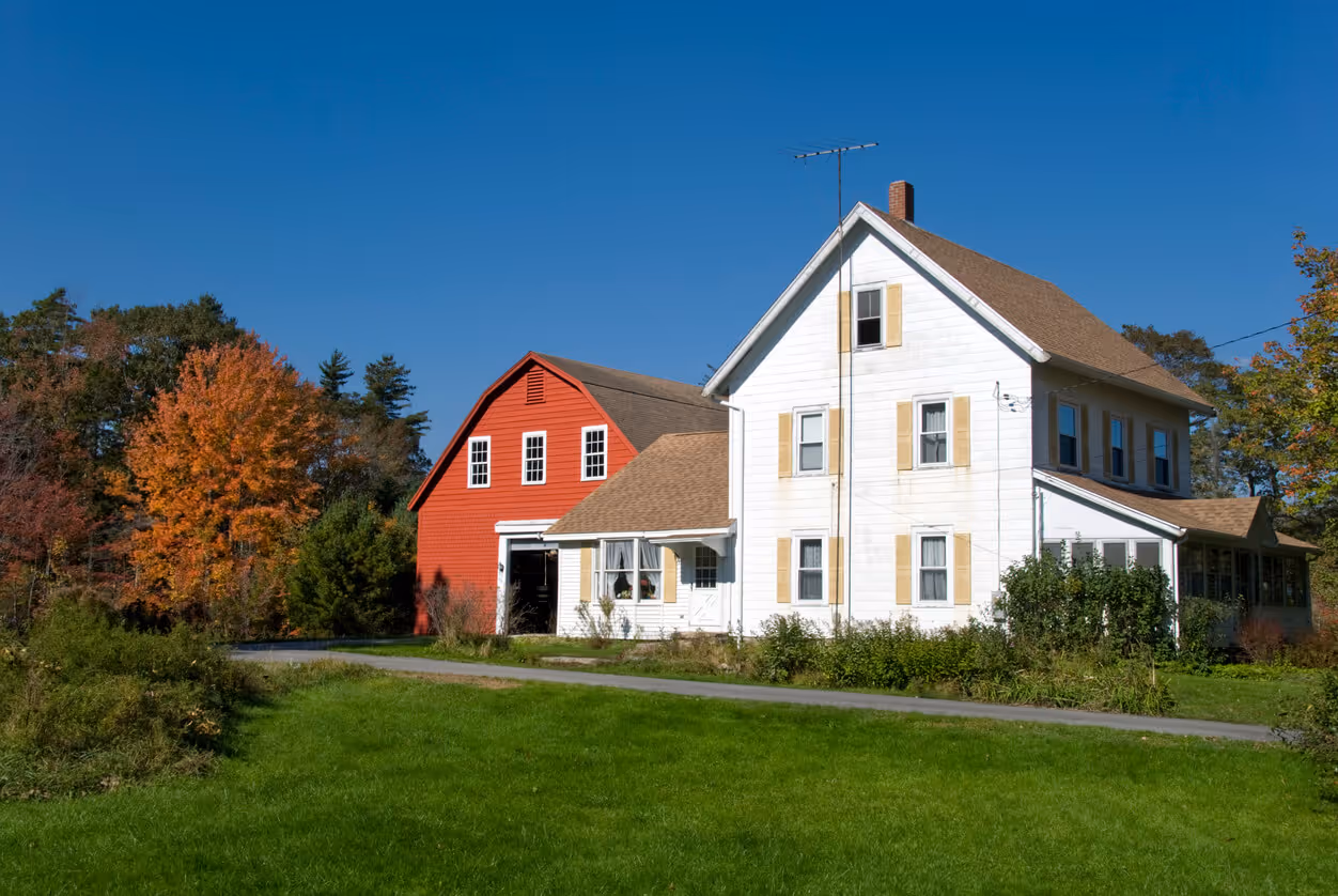 Fall foliage and farmhouse in New England, USA.