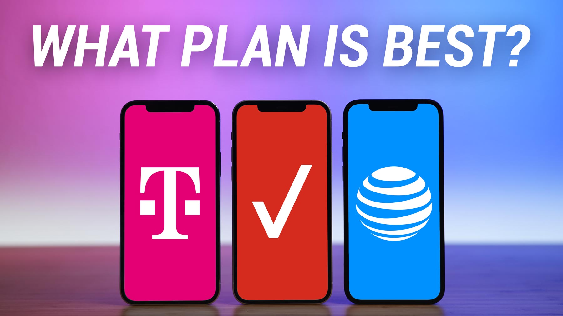 three iPhones standing vertically on desk with T-Mobile, Verizon, and AT&T logos displayed on screen