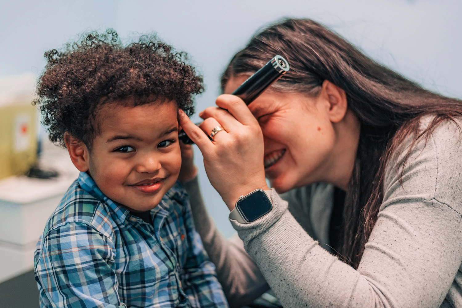 A woman is helping a young boy