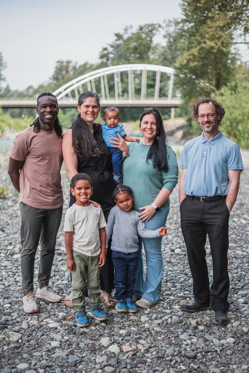 Seek Optimal Family poses for a picture in front of a bridge.