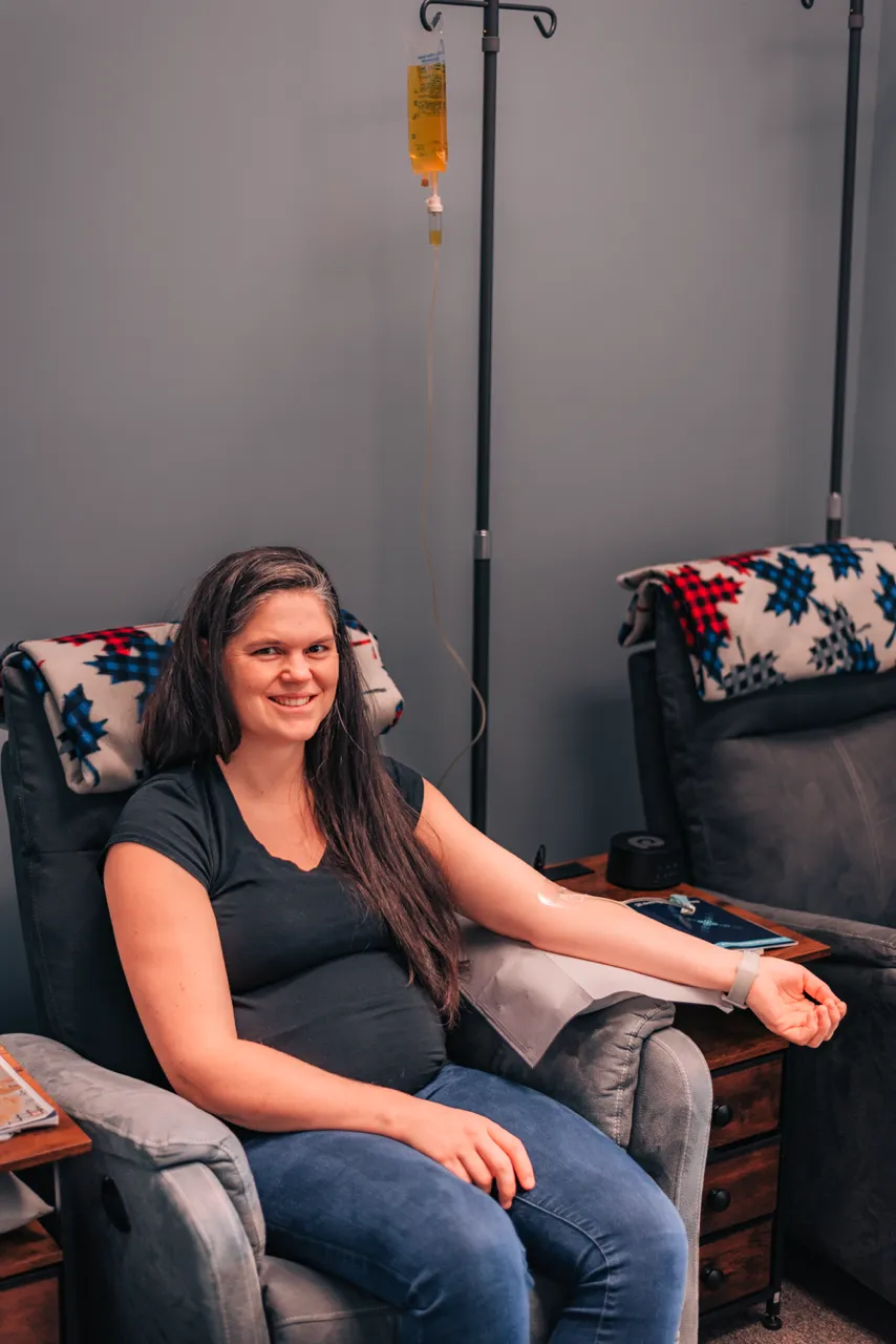 Patient relaxing in a recliner while receiving an IV infusion.