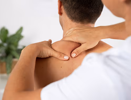 Therapist applying pressure to a client’s shoulder and neck.