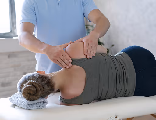 Clinician assisting a patient with a side-lying hip/lower-back mobilization.
