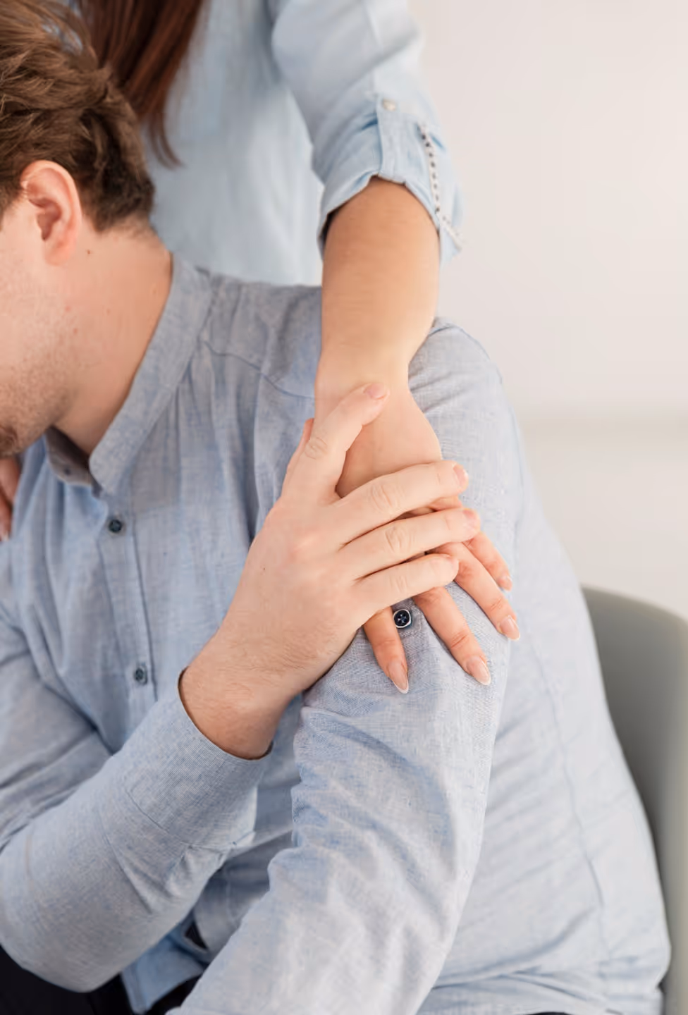 A comforting gesture where a person places their arm and hand on another person’s shoulder.