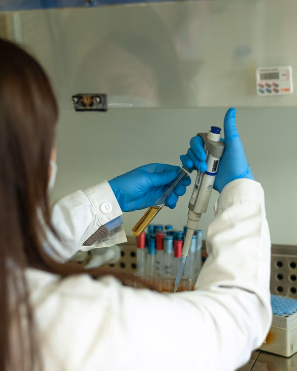 A woman in a lab coat holding a test tube.