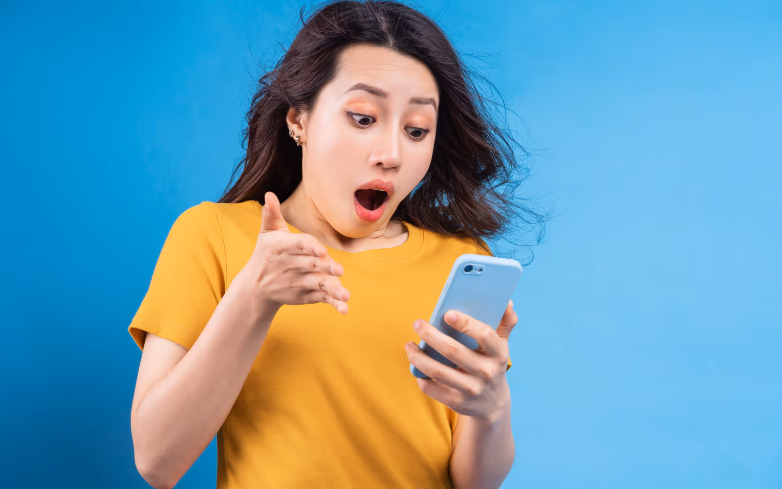 Person looking at a phone and looking surprised. 