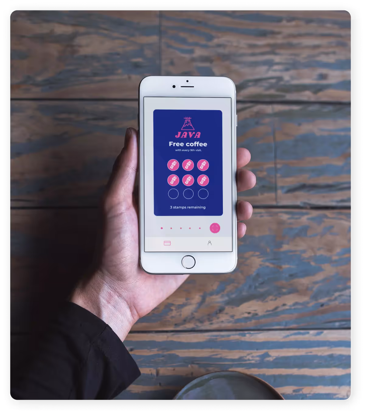 Hand holding a phone with the Stampede app interface.