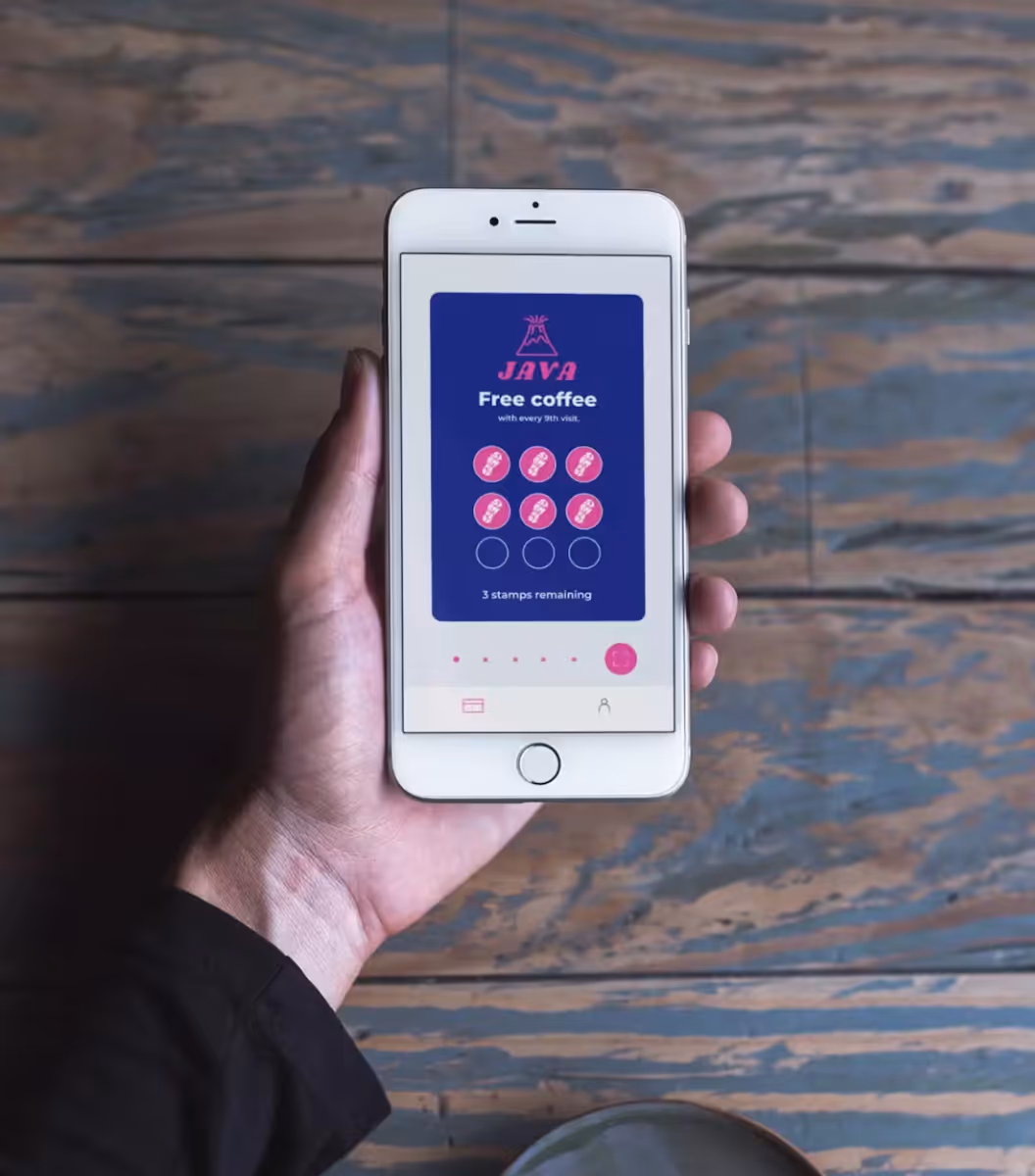 Hand holding a phone with the Stampede app open.