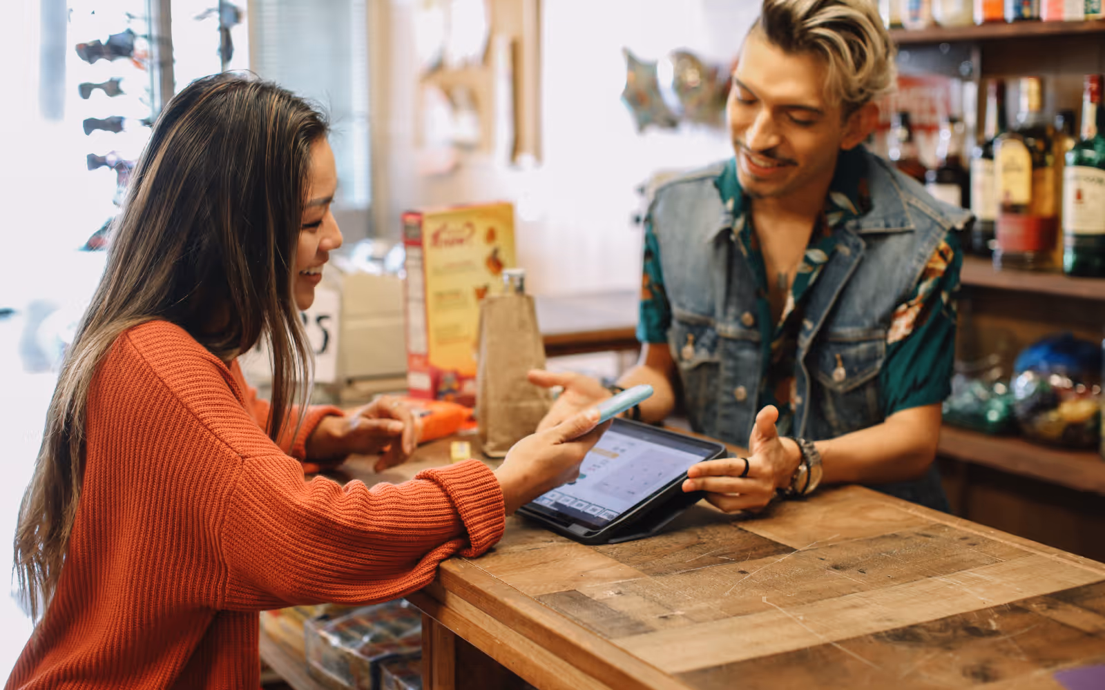 A customer using their phone over a tablet at a store.