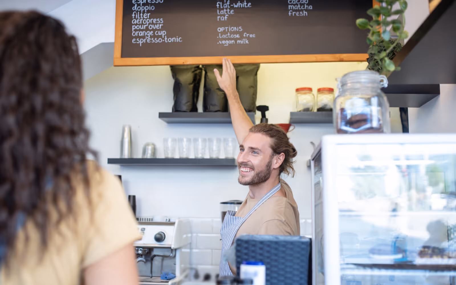 barista pointing to a cafe menu