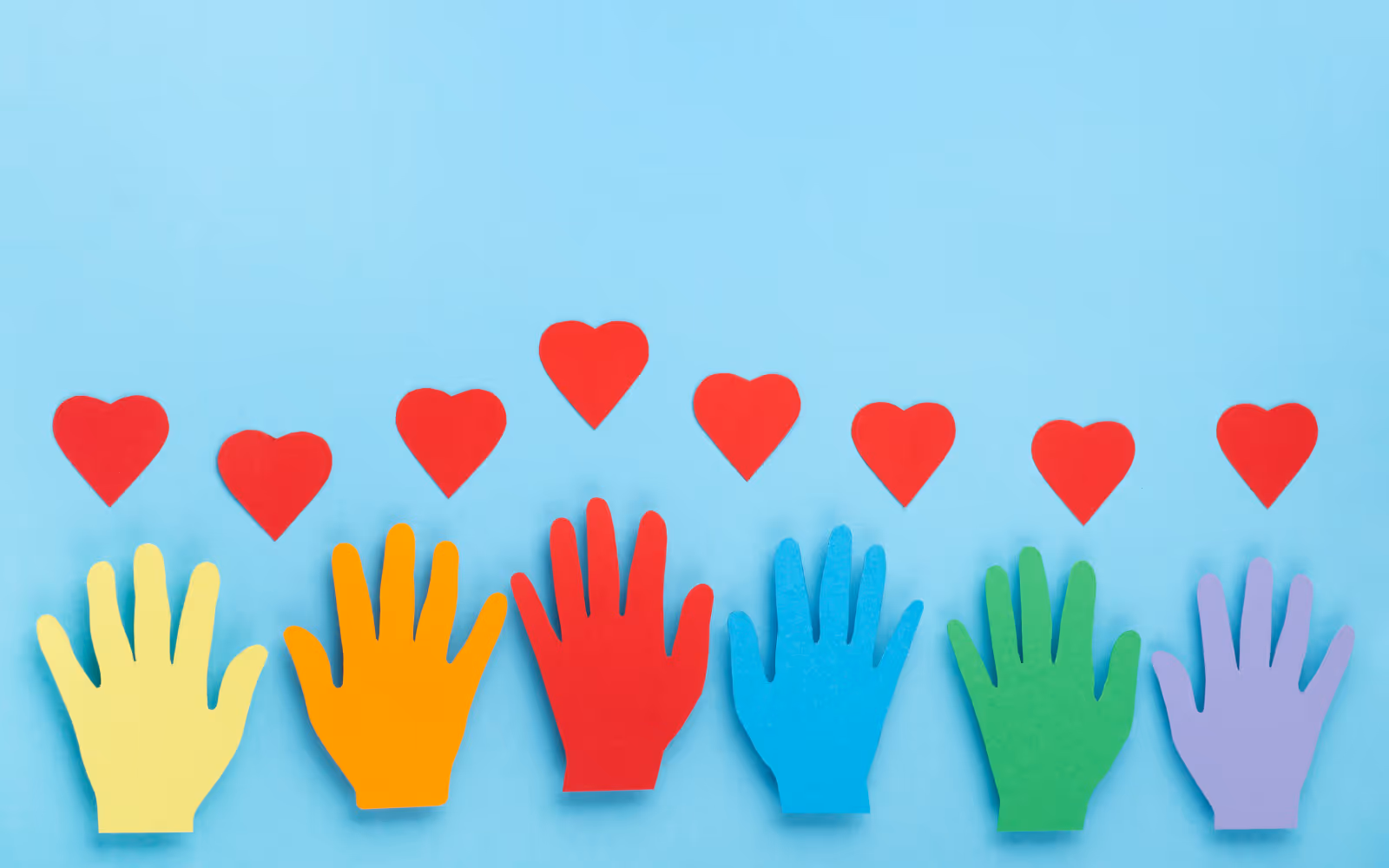 Colored hands with red hearts above them over a blue background.