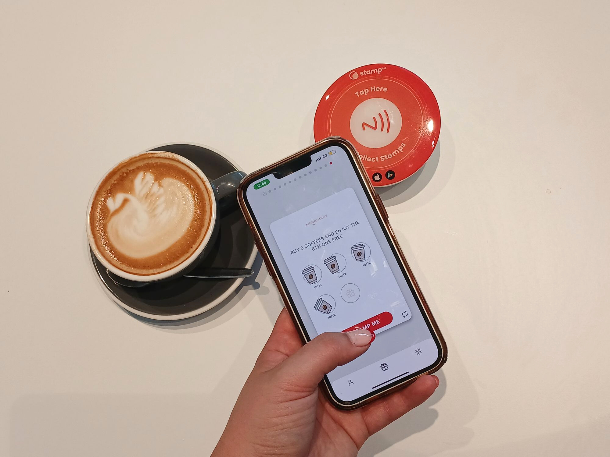 Cafe staff using Stamp Me's StampPod to validate a digital loyalty card at the counter