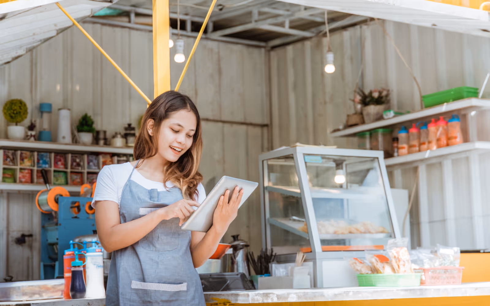 Small business owner using an iPad to manage their digital loyalty program, ideal for cafes, salons, and independent retailers.