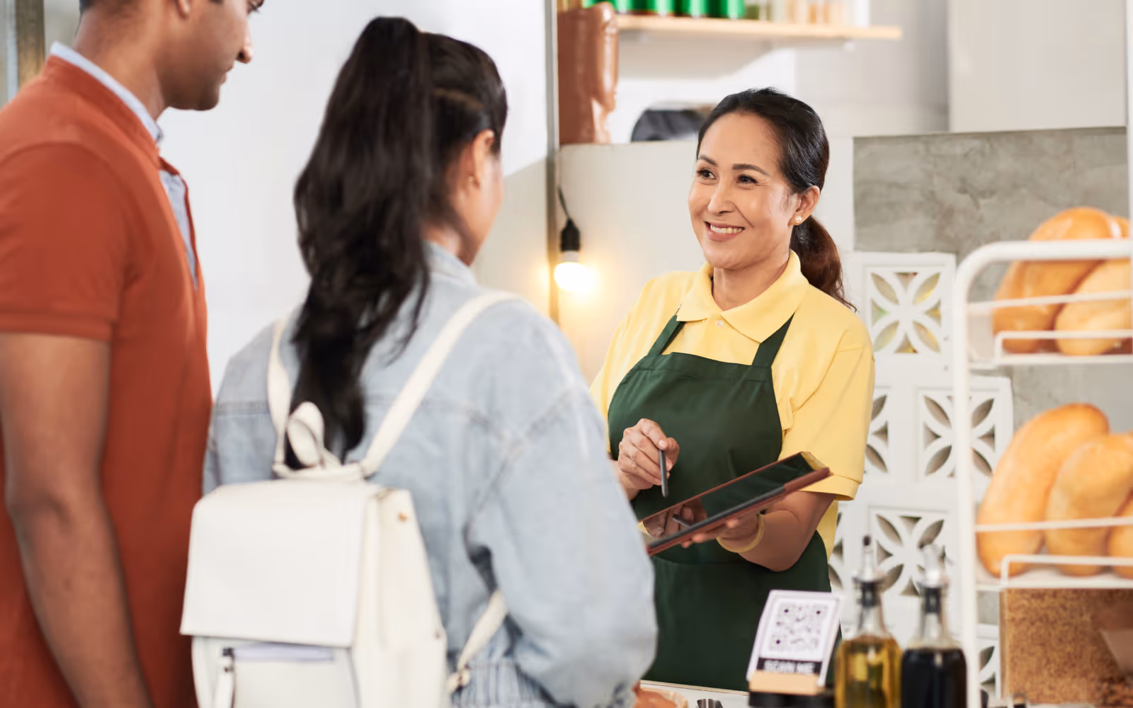 Friendly staff member chatting with a smiling customer at a local business, creating a positive in-store experience.