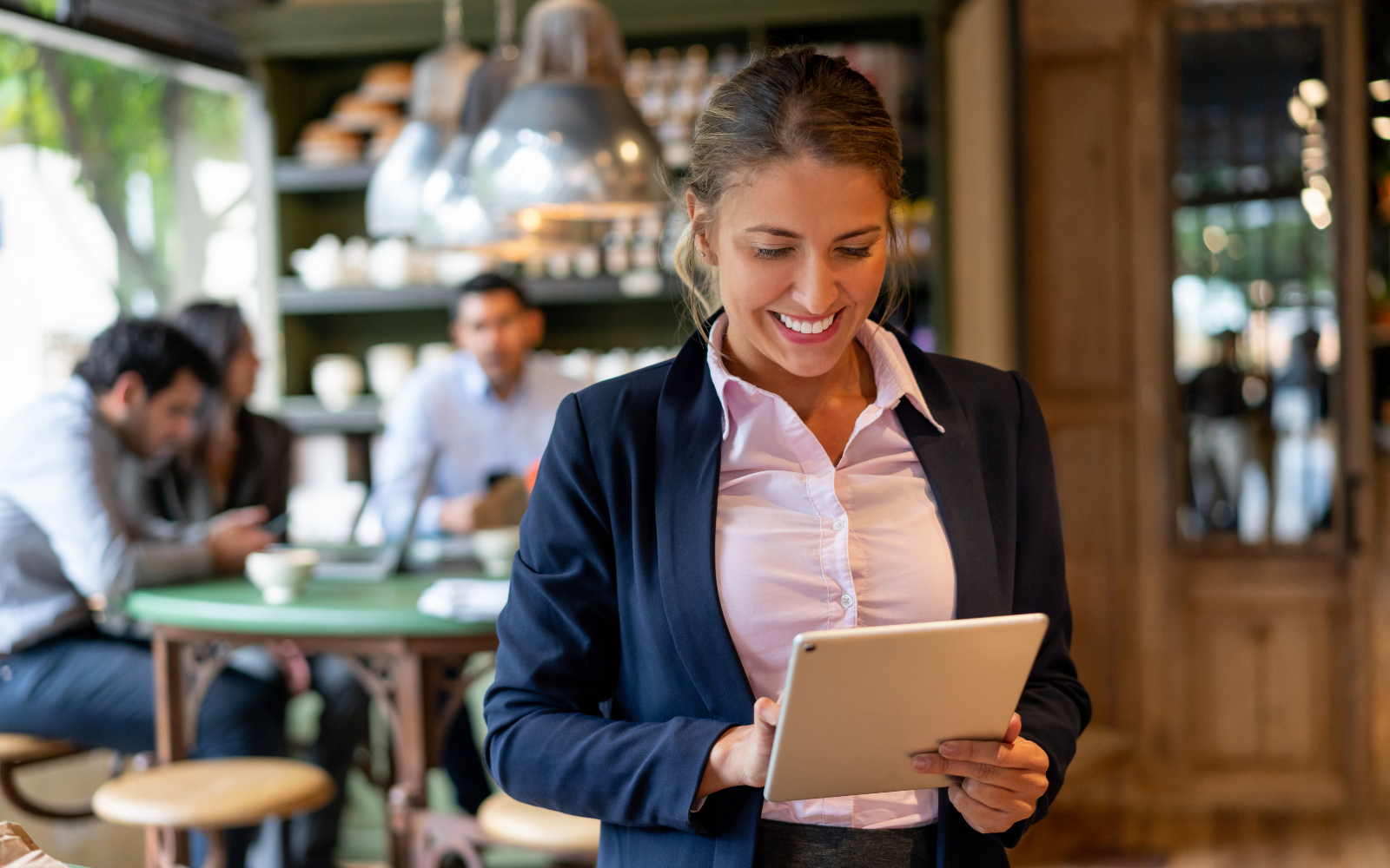 Happy restaurant owner smiling while overseeing operations and interacting with their loyalty program in their restaurant.