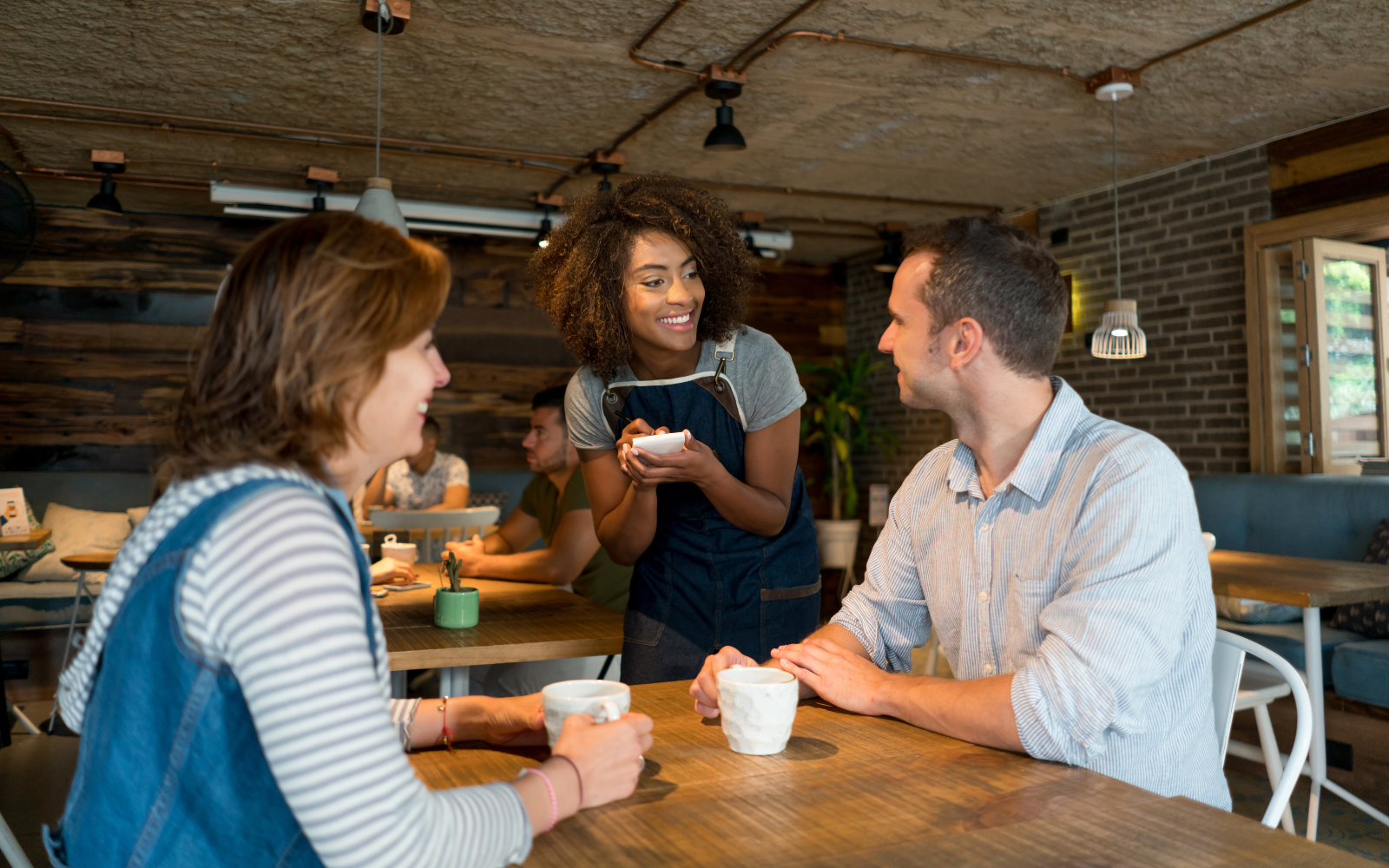 Happy customers enjoying coffee at a Canadian cafe, highlighting cafe loyalty programs and customer rewards.