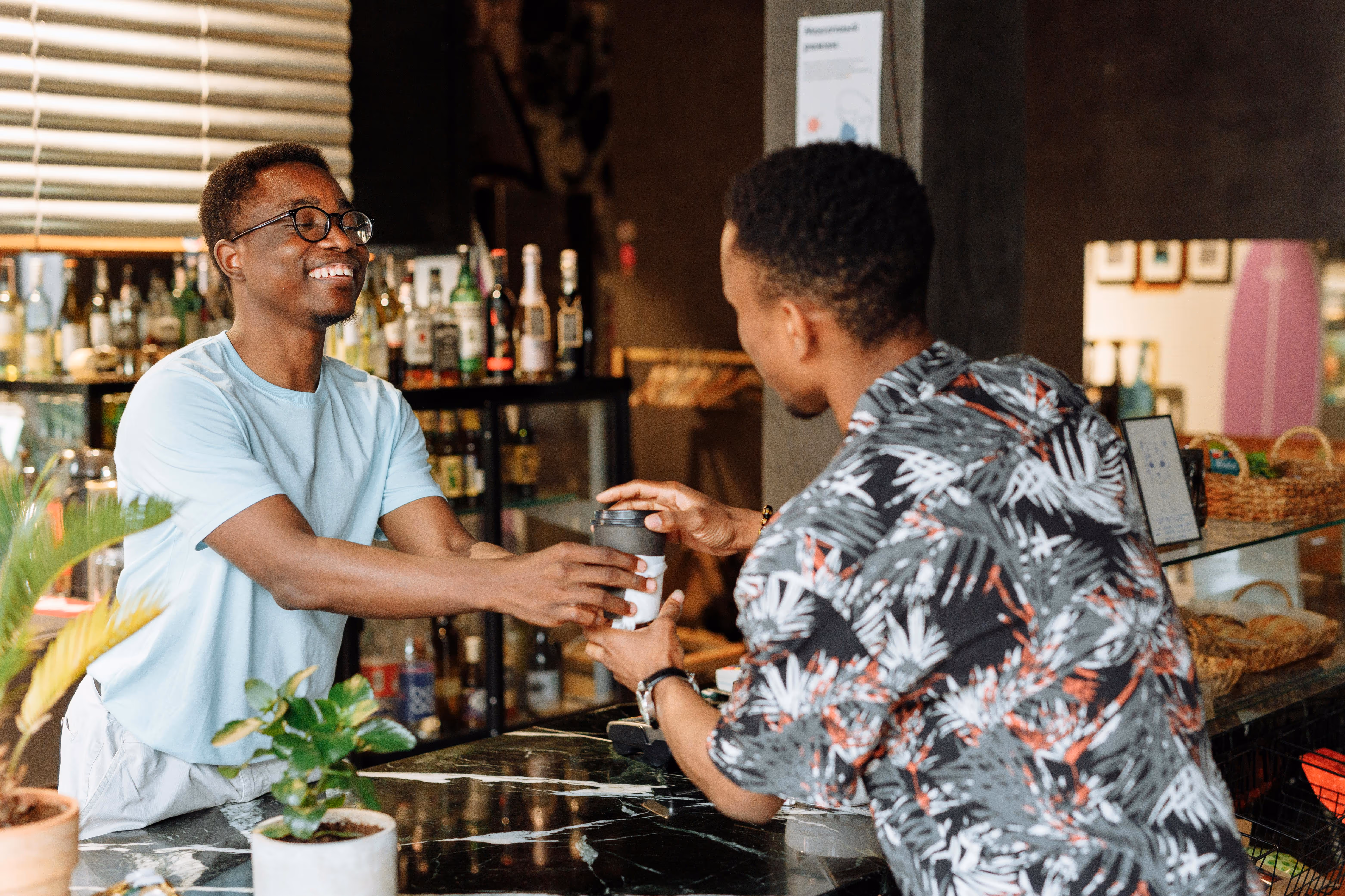 Barista serving a smiling regular.