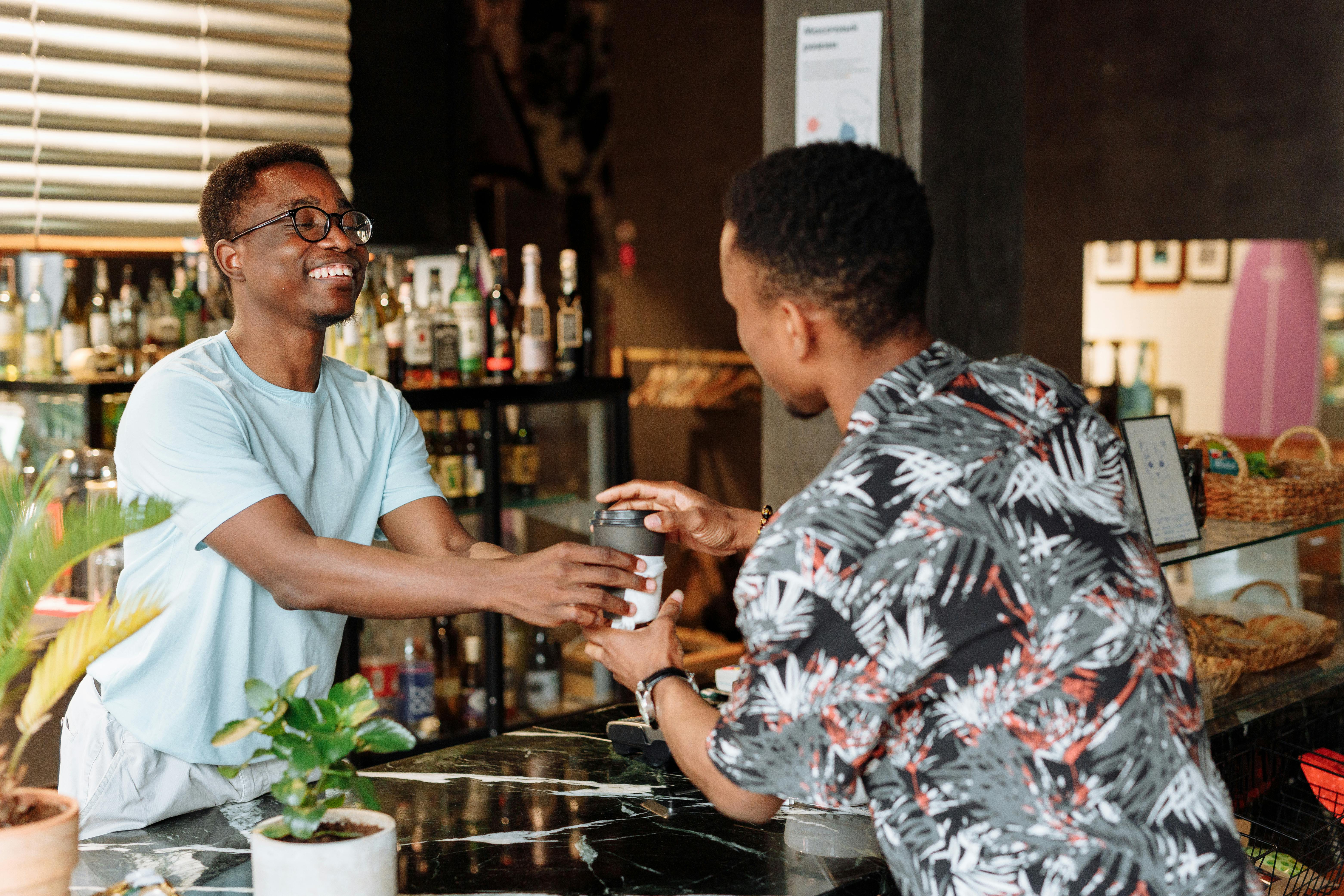 Barista serving a smiling regular.