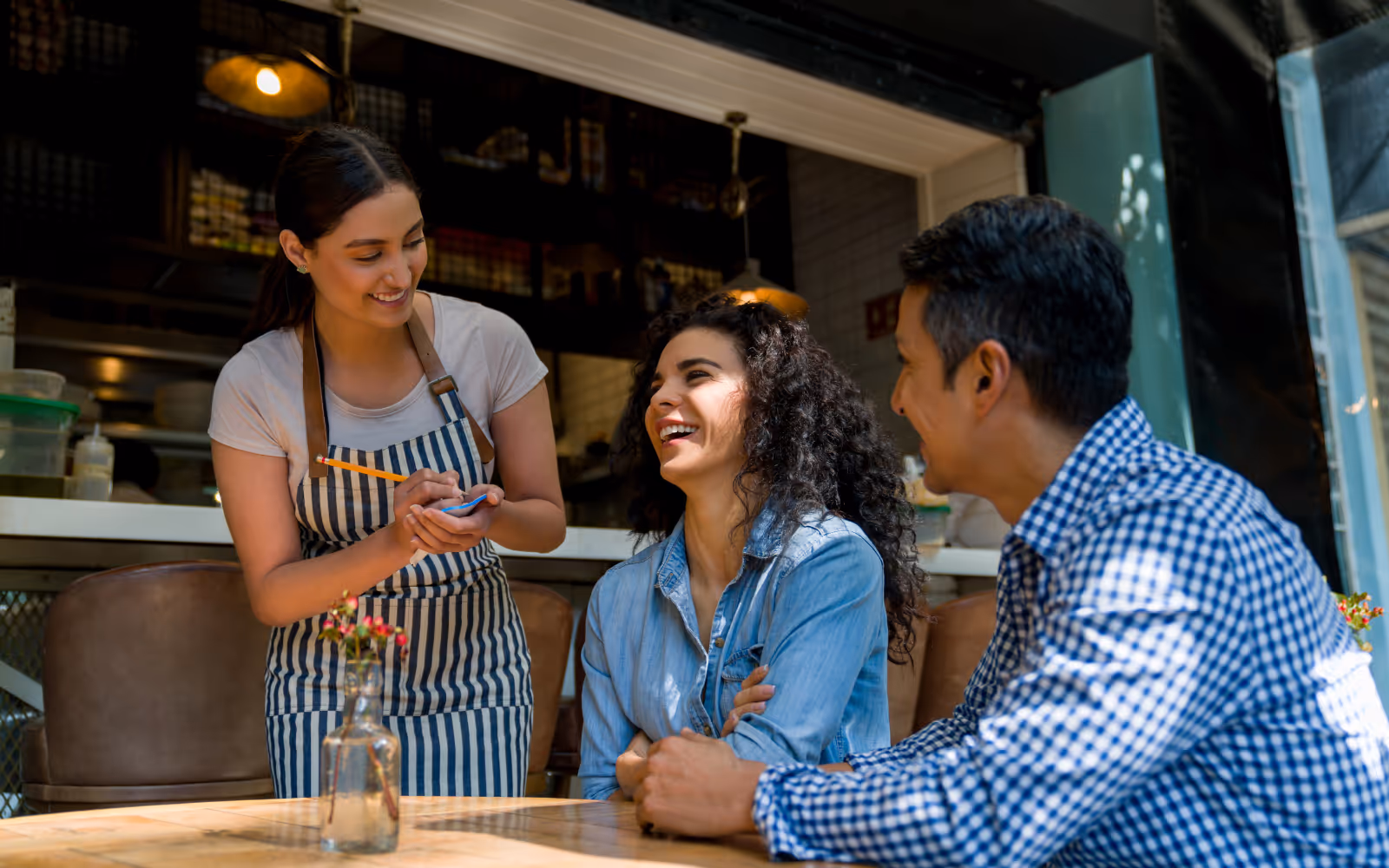 Happy restaurant customers enjoying their meal, showing the impact of customer loyalty programs ROI on repeat visits and retention