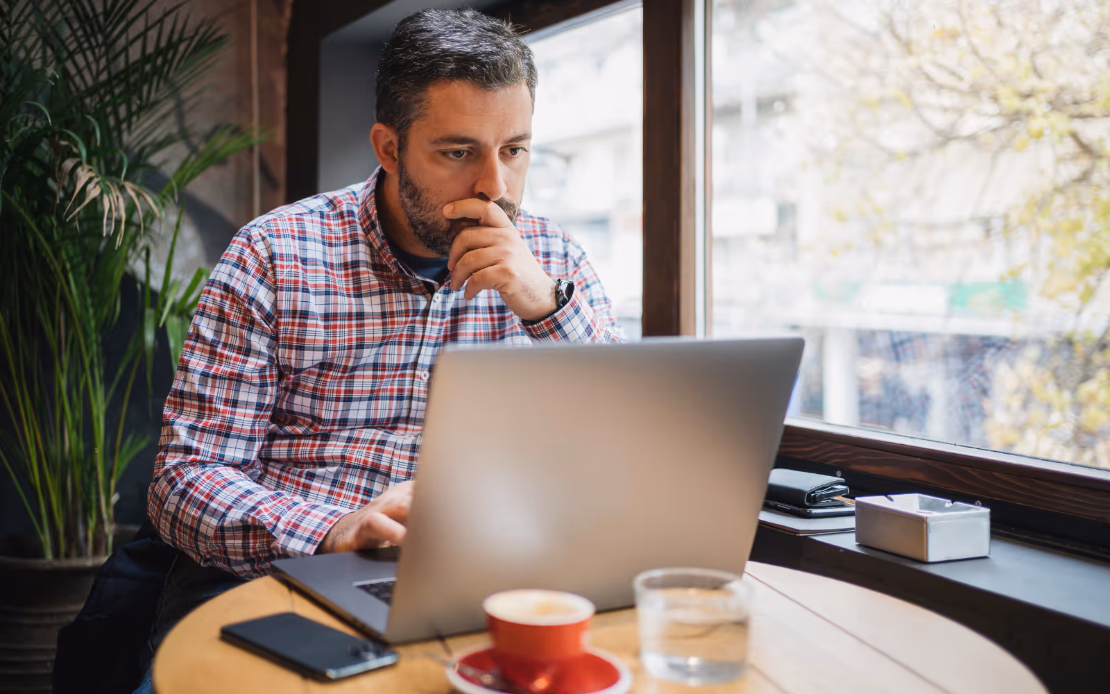 A business owner reviewing loyalty program data and considering a switch from paper punch cards to digital.