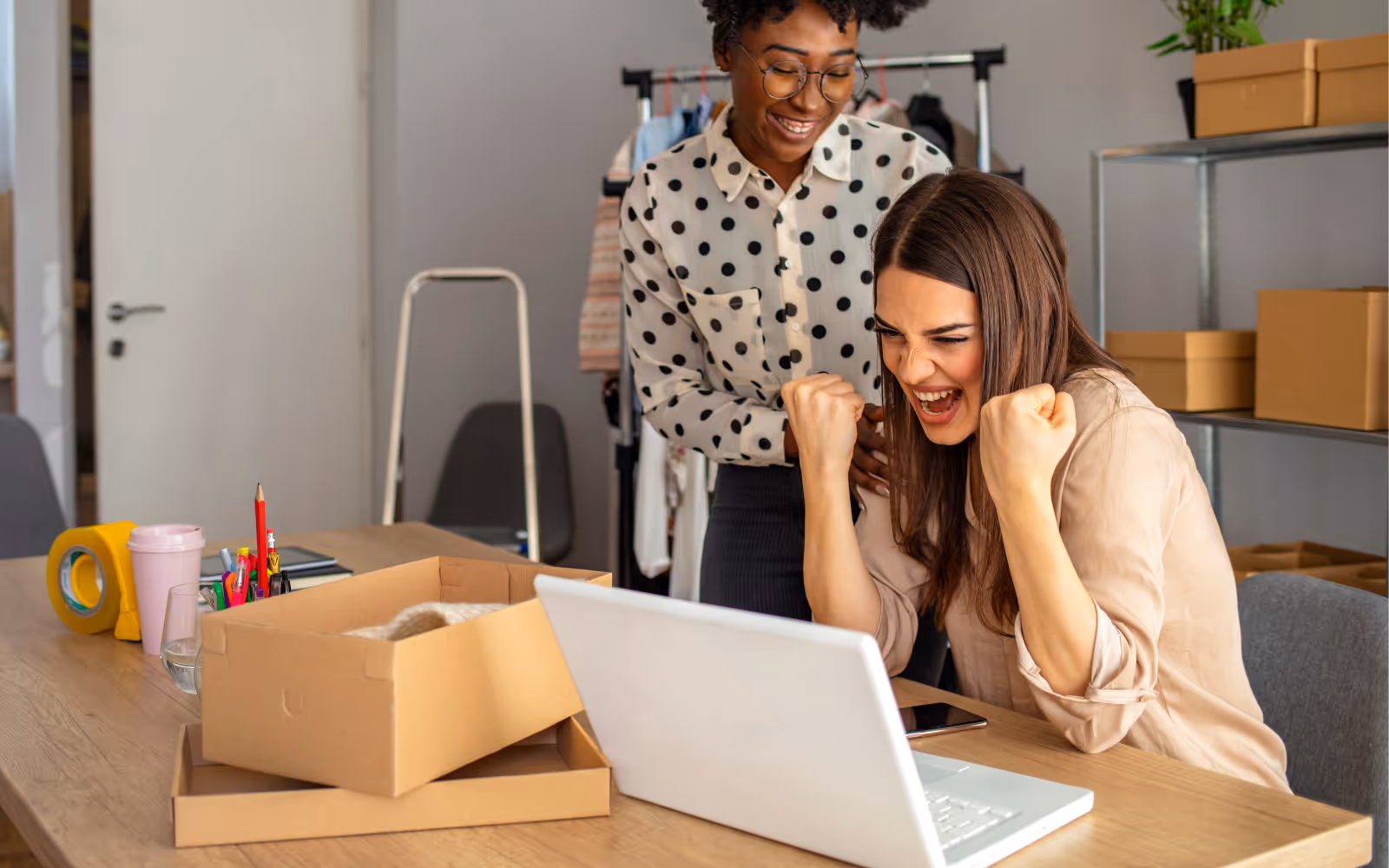 Small business owner smiling while using a computer, representing satisfaction with setting up and managing their digital loyalty program through Stamp Me.