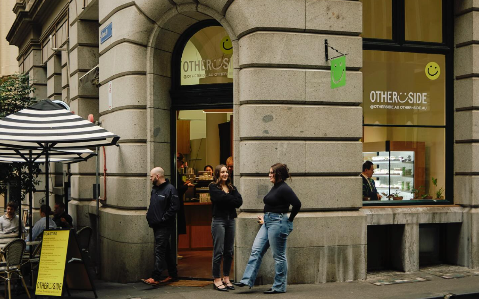 Busy Australian CBD cafe with takeaway coffee customers during morning rush