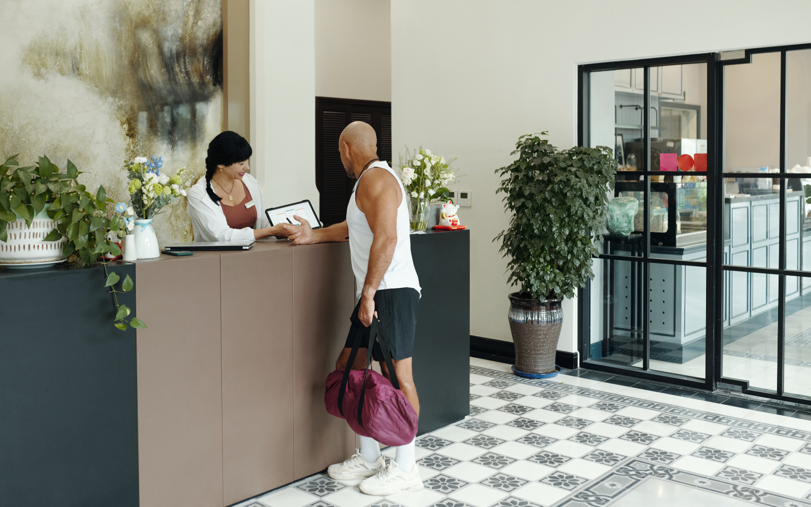 Yoga studio staff showing digital loyalty app to members during class check-in.