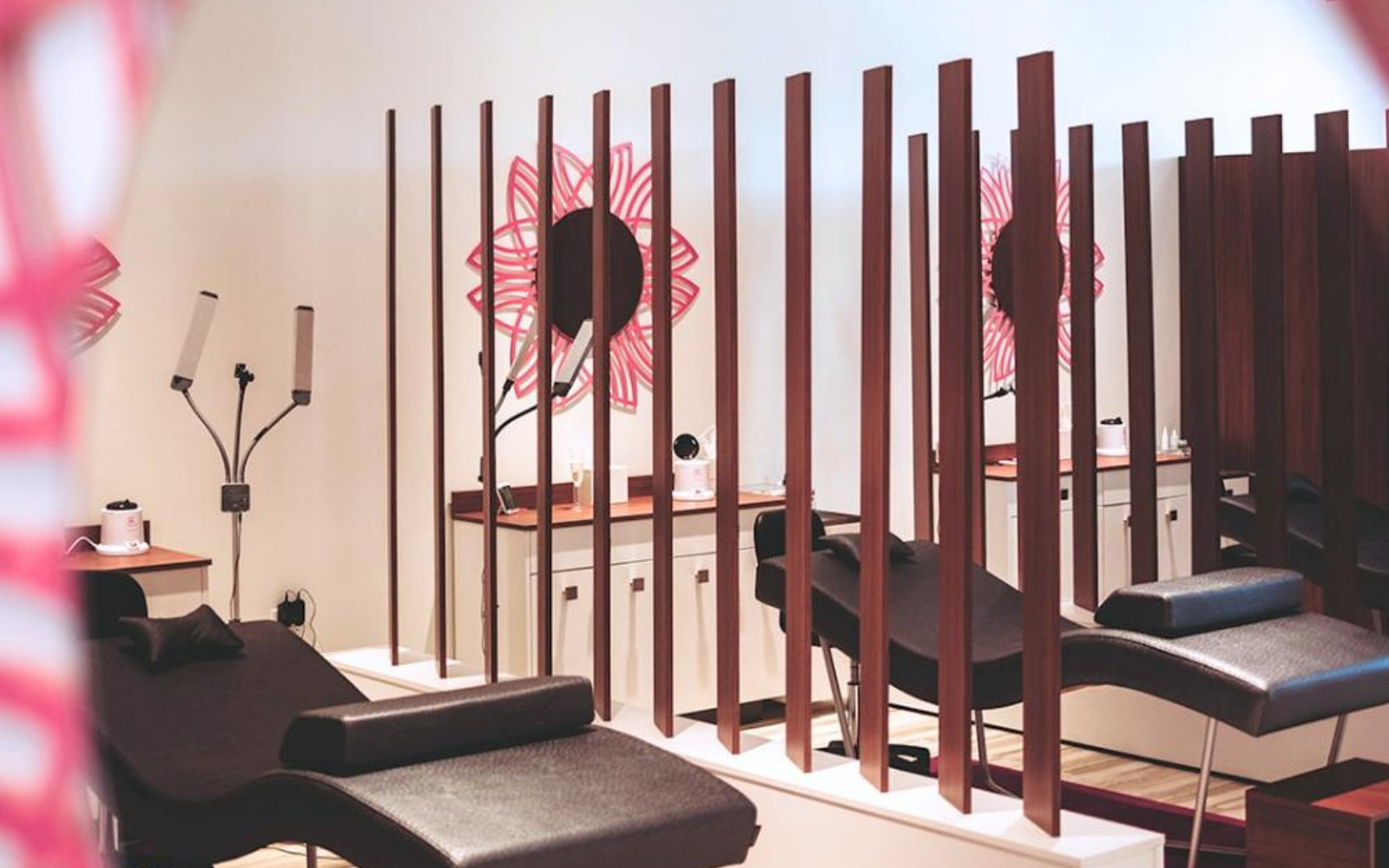 Deka Lash beauty studio interior with customer checking in and using a digital loyalty app across franchise locations.